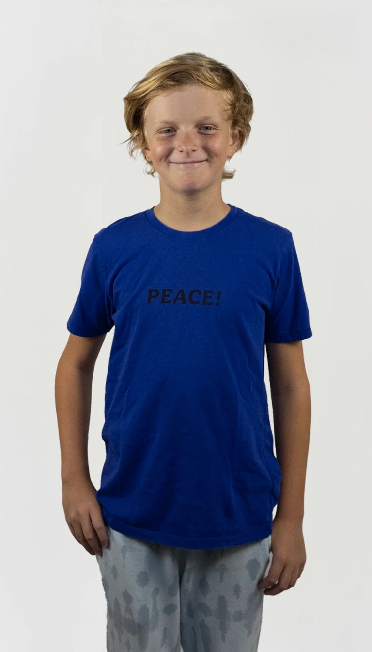 Kid wearing an organic cotton blue t-shirt with the word 'PEACE!' on a white background